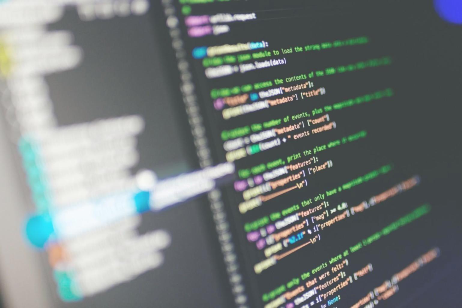 Ambiente di lavoro con monitor che mostrano codice di prototipazione e interfacce di gioco